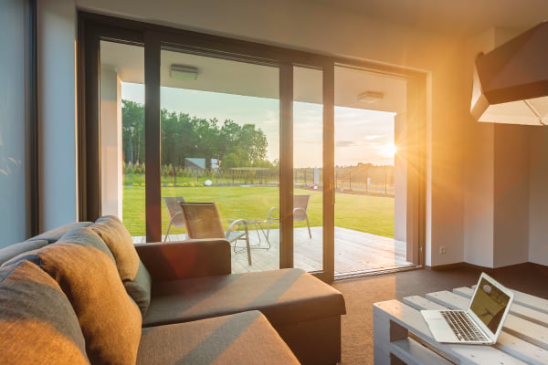 Modernes Wohnzimmer mit offener Terrassentüre mit Blick ins Grüne