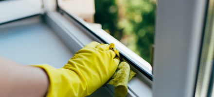 Frau mit gelben Handschuhen, die Fenster Puzt