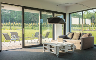 Wohnzimmer mit Blick nach ins grüne durch große Terrassentür